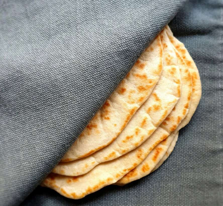 Image of flat bread under a gray cloth