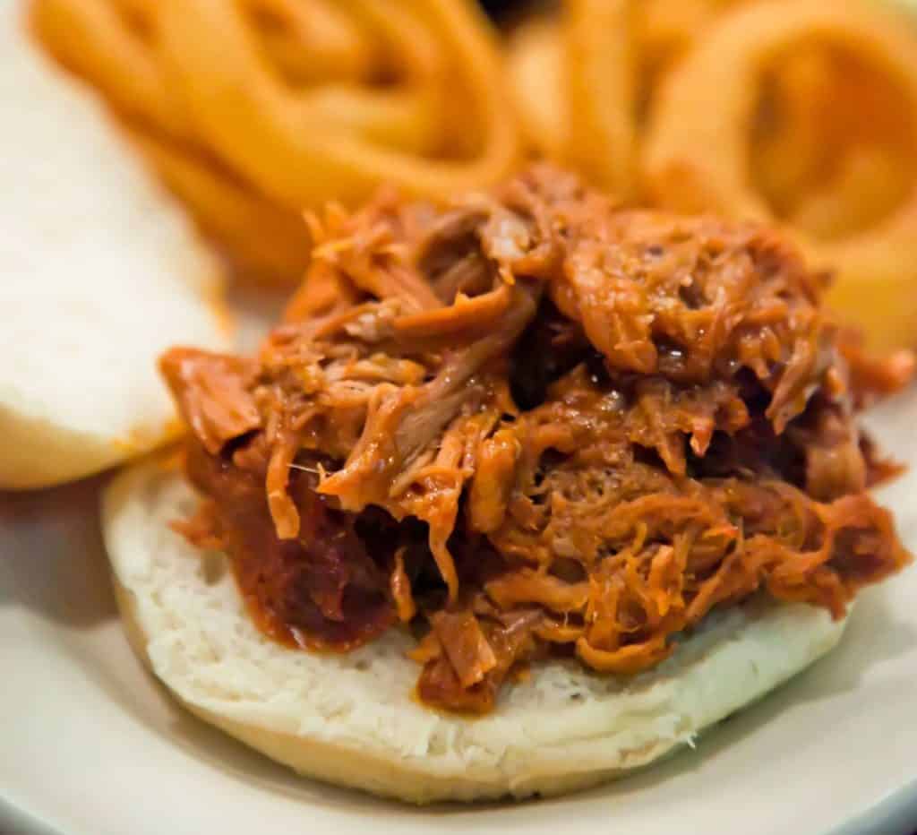Pulled pork sandwich with onion rings from Twin Anchors
