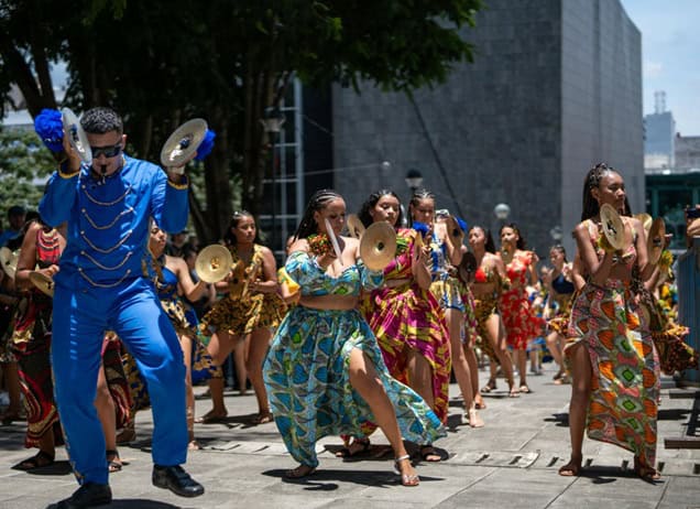 Festival goers in Costa Rica wearing colorful outfits and holding cymbals