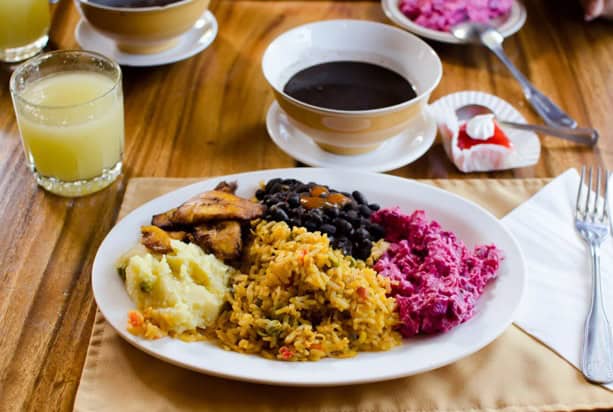Plate in costa rica with food including rice, black beans, plantains, juice, and coffee